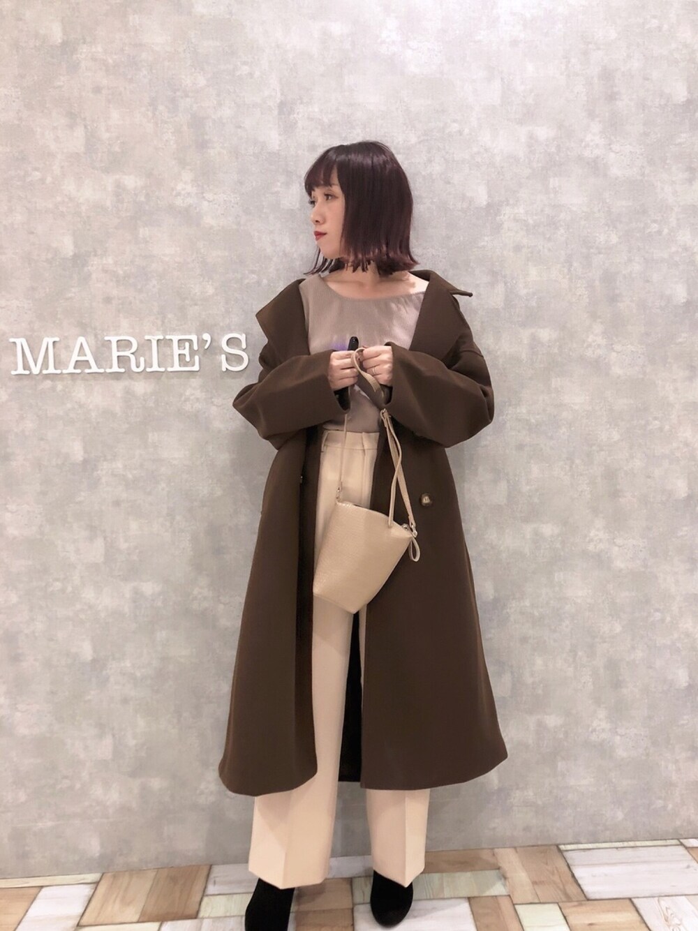 ブラウン系のチェスターコート、ベージュ系のその他パンツ、ブラウン系のTシャツ/カットソーを着用したレディースの秋コーディネートの1枚目の写真