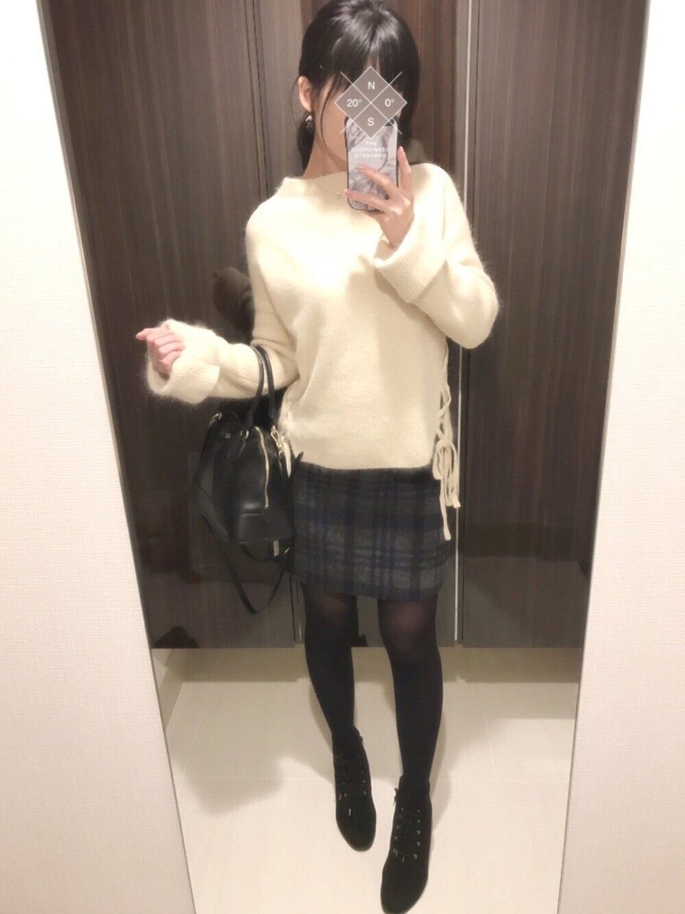 ブラック系のブーツ、ブルー系のスカート、ブラック系のショルダーバッグを着用したレディースの冬コーディネートの1枚目の写真