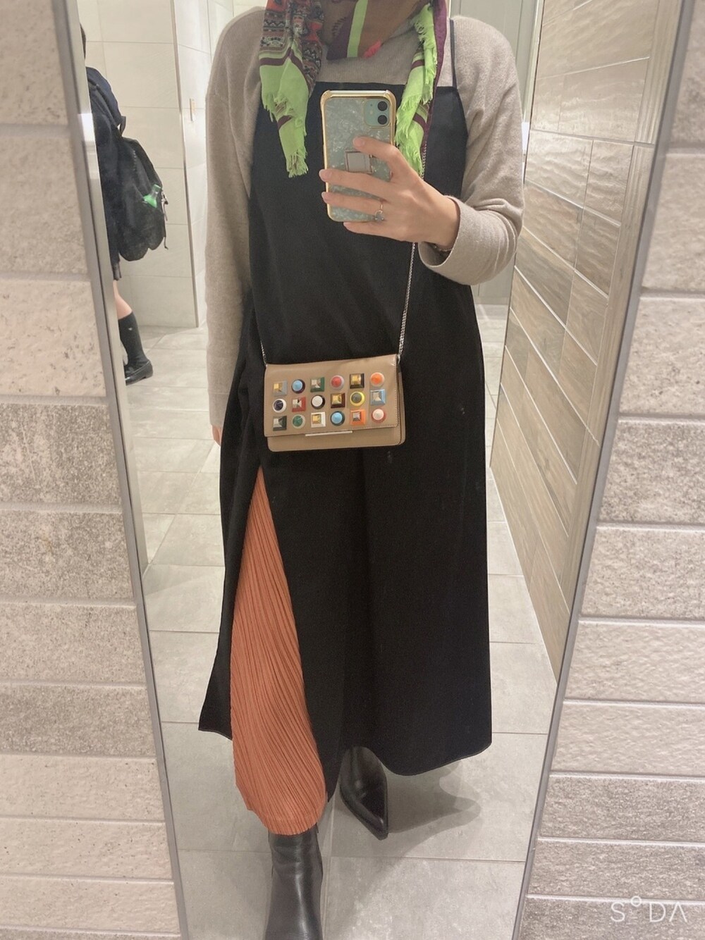 ベージュ系のショルダーバッグ、ブラウン系のマフラーを着用したレディースの冬コーディネートの1枚目の写真