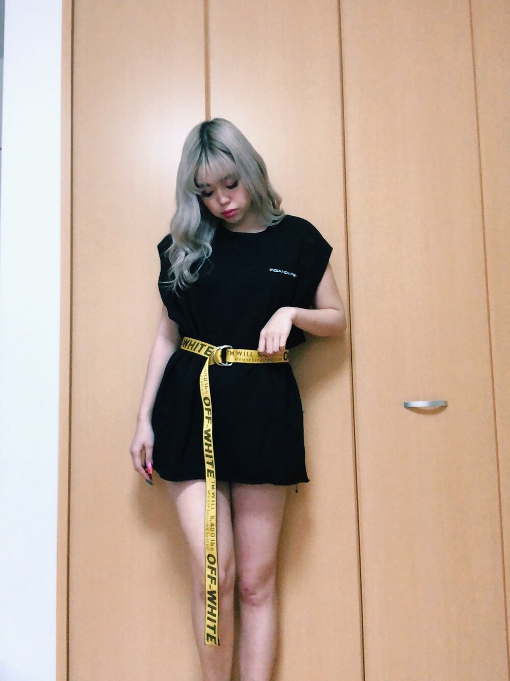 ブラック系のTシャツ/カットソー、イエロー系のベルトを着用したレディースの春コーディネートの1枚目の写真