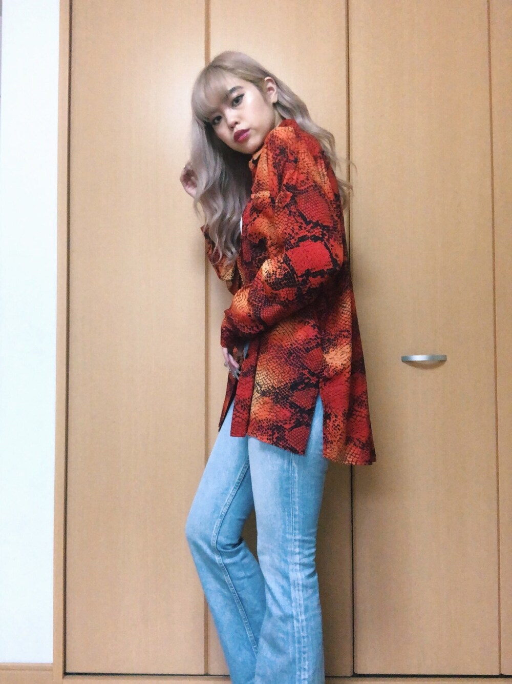 レッド系のシャツ/ブラウス、ホワイト系のチューブトップ、ブルー系のデニムパンツを着用したレディースの春コーディネートの1枚目の写真