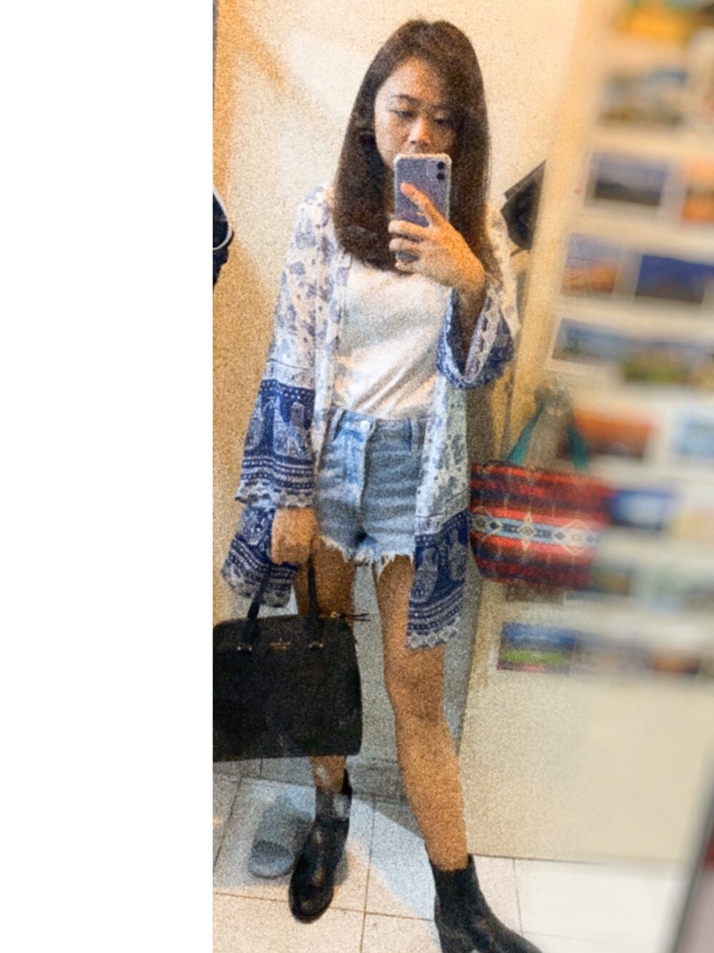 ブルー系のポンチョ、ブルー系のカーゴパンツ、ブラック系のトートバッグを着用したレディースの冬コーディネートの1枚目の写真