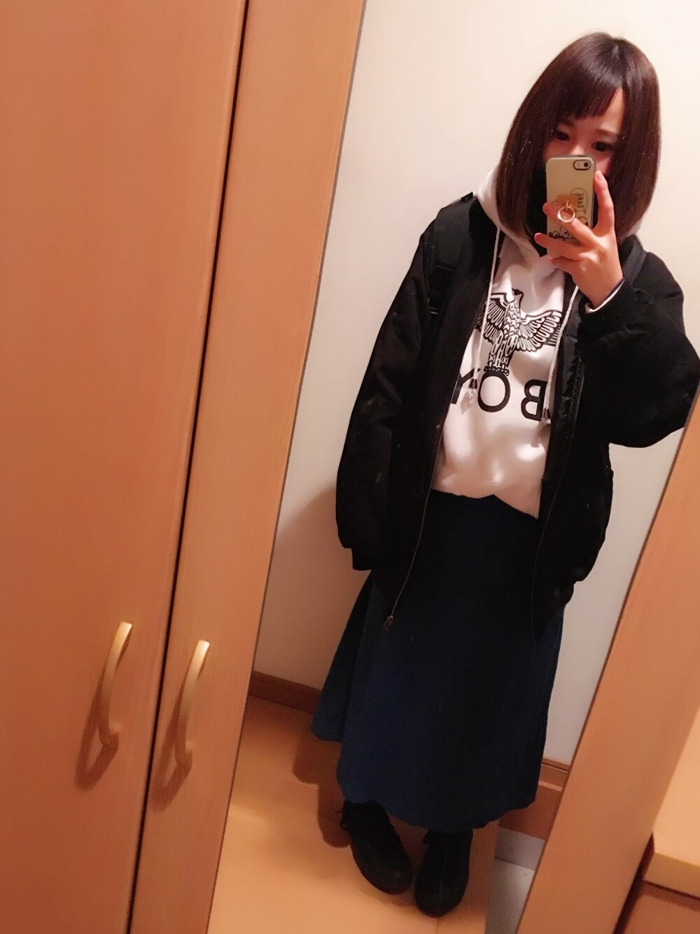 ブラック系のMA-1、ホワイト系のパーカー、ブラック系のスニーカーを着用したレディースの冬コーディネートの1枚目の写真