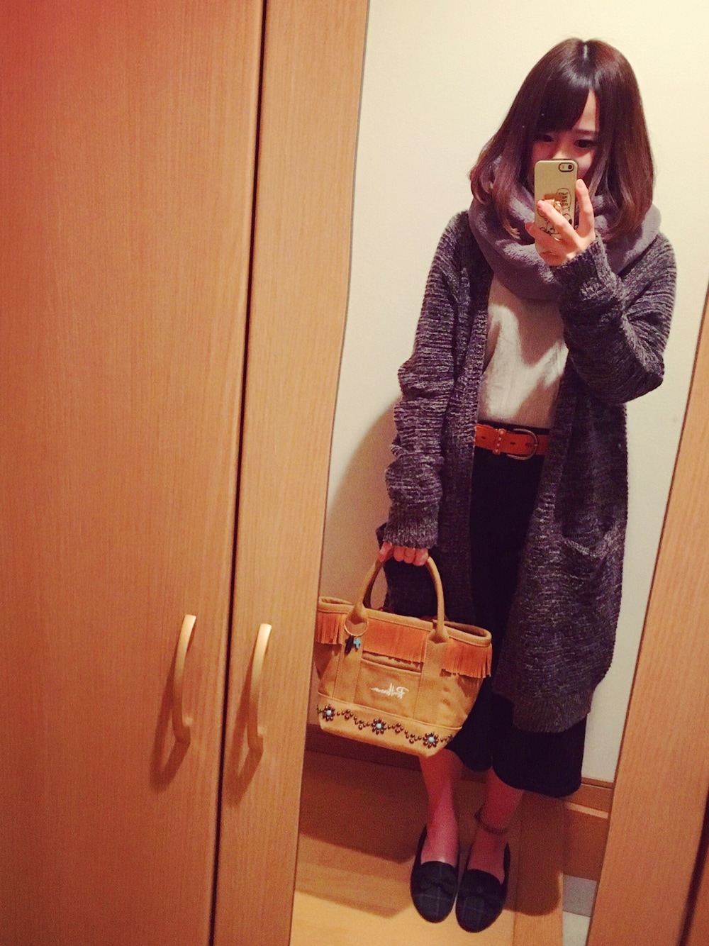 ブラック系のジャケット/アウター、ブラウン系のトートバッグ、グレー系のマフラーを着用したレディースの冬コーディネートの1枚目の写真