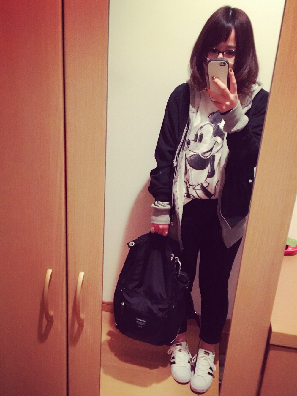 ホワイト系のスニーカー、ブラック系のバックパック/リュック、ホワイト系のトップスを着用したレディースの春コーディネートの1枚目の写真