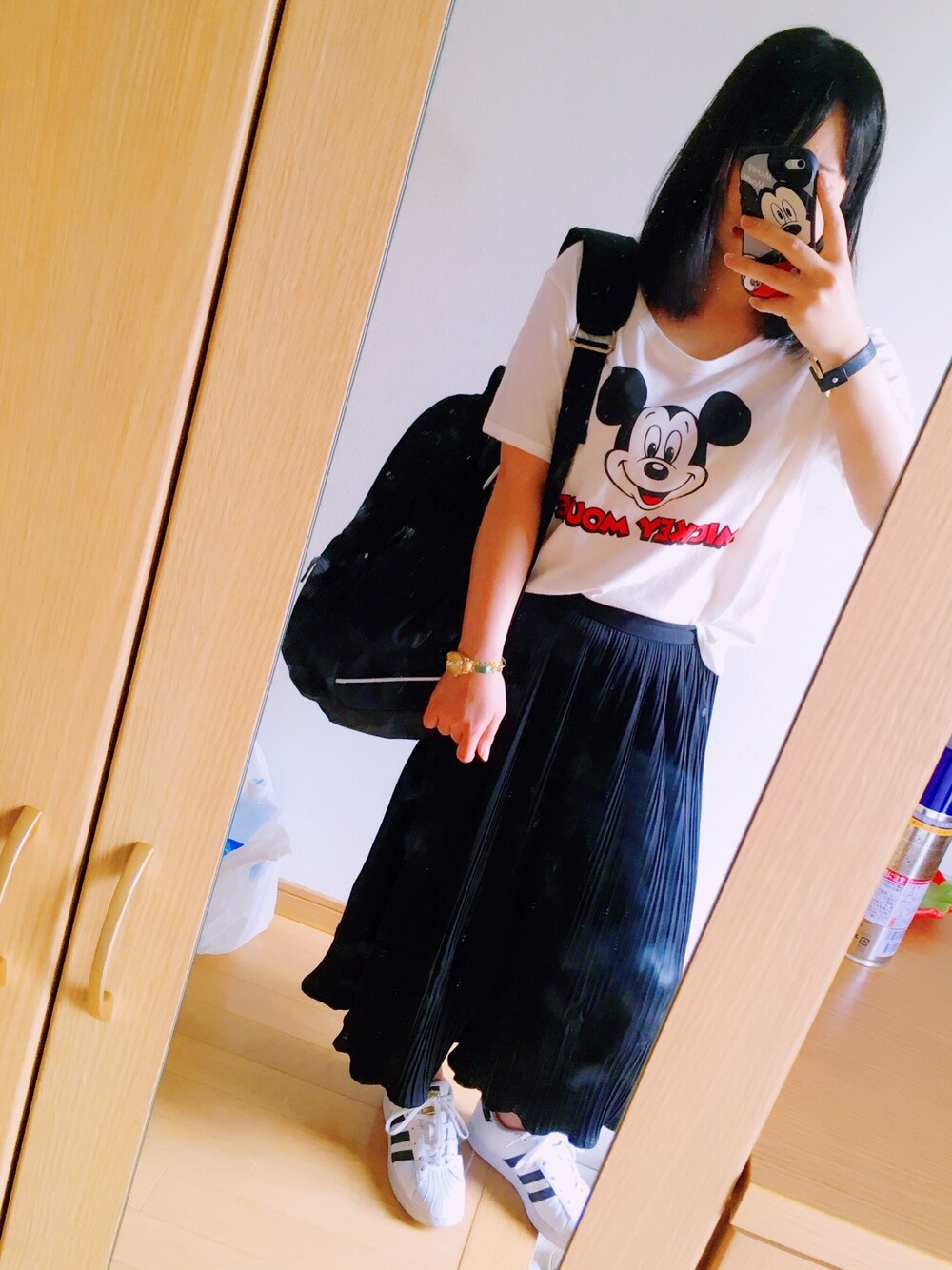 ブラウン系のパンツ、ホワイト系のスニーカー、ブラック系のバックパック/リュックを着用したレディースの夏コーディネートの1枚目の写真