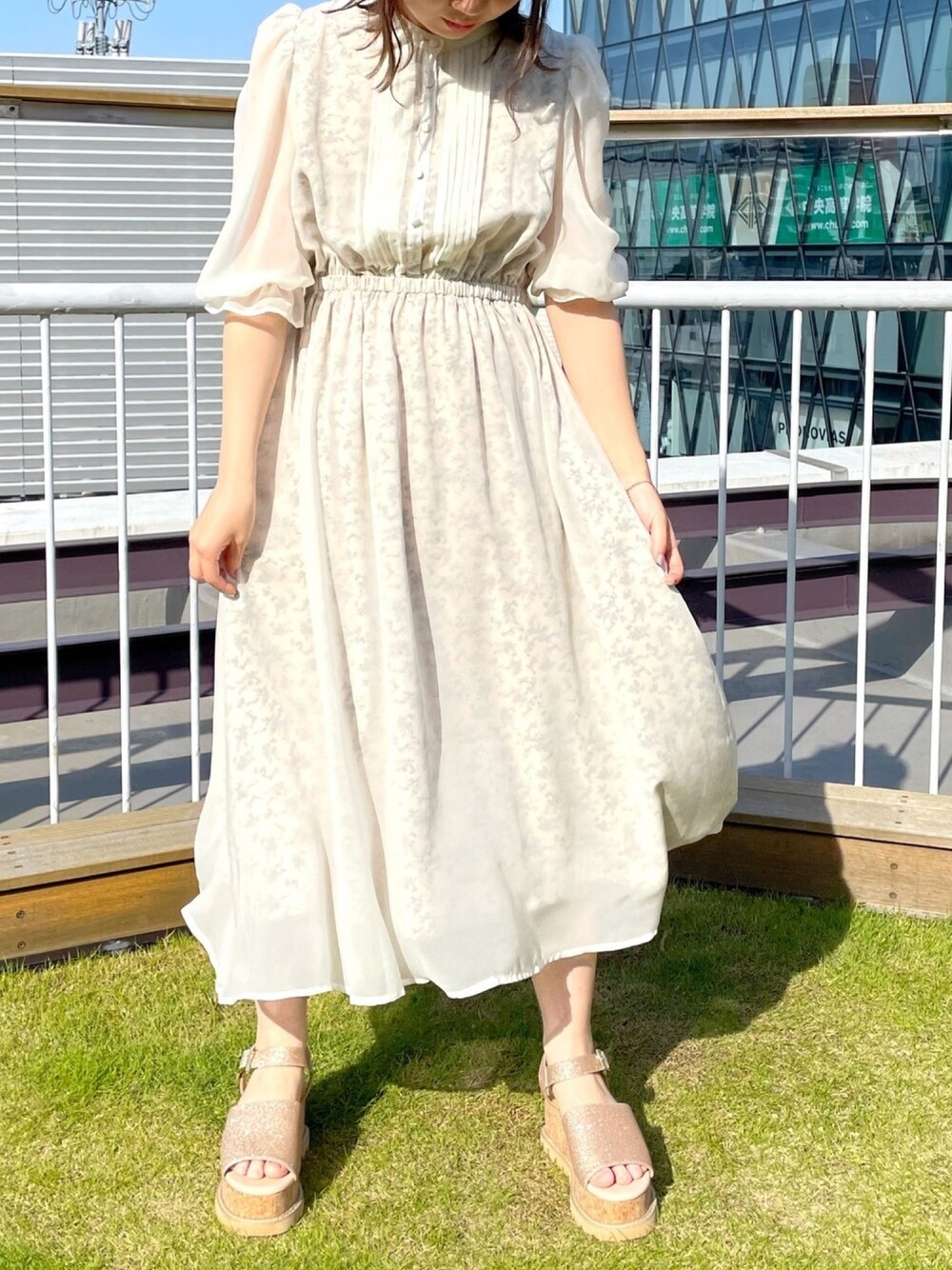 ホワイト系のワンピース、ゴールド系のサンダル、ホワイト系のその他を着用したレディースの春コーディネートの1枚目の写真