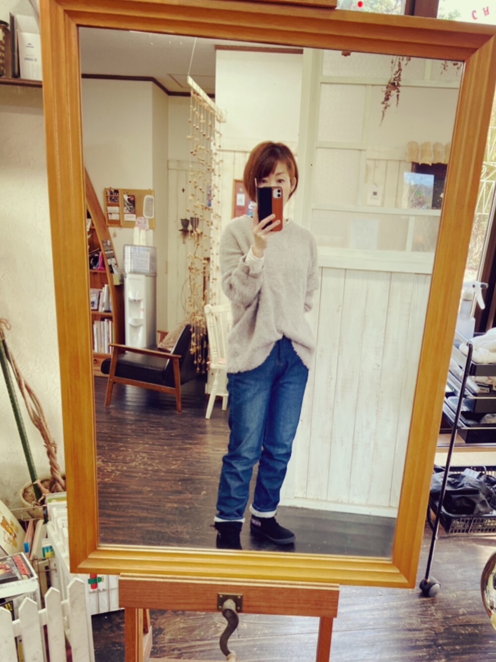 シルバー系のニット/セーター、ブルー系のデニムパンツ、ブラック系のシューズを着用したレディースの冬コーディネートの1枚目の写真