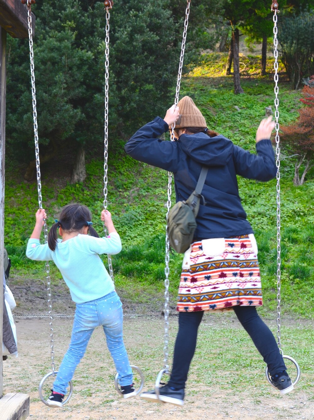 グリーン系のボディバッグ/ウエストポーチ、ブルー系のマウンテンパーカー、その他のスカートを着用したレディースの春コーディネートの1枚目の写真