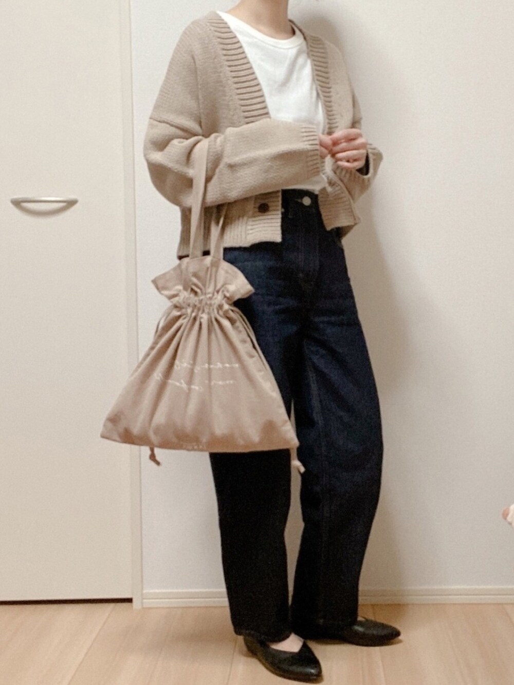 ベージュ系のカーディガン/ボレロ、ホワイト系のTシャツ/カットソー、ブルー系のデニムパンツを着用したレディースの春コーディネートの1枚目の写真