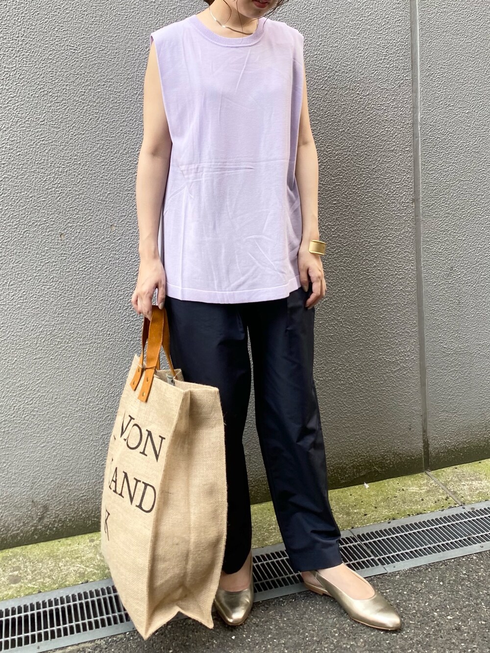 パープル系のニット/セーター、ブルー系のその他パンツ、ゴールド系のパンプスを着用したレディースの春コーディネートの1枚目の写真