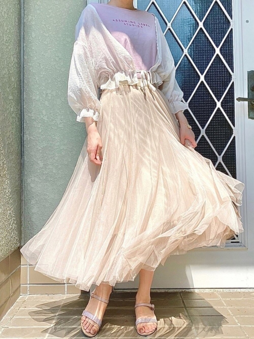 ベージュ系のスカート、ホワイト系のカーディガン/ボレロ、シルバー系のサンダルを着用したレディースの夏コーディネートの1枚目の写真