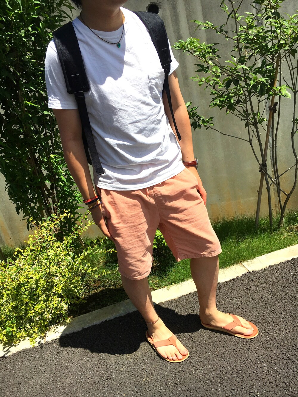 ホワイト系のTシャツ/カットソー、レッド系のその他パンツ、ピンク系のビーチサンダルを着用したメンズの夏コーディネートの1枚目の写真