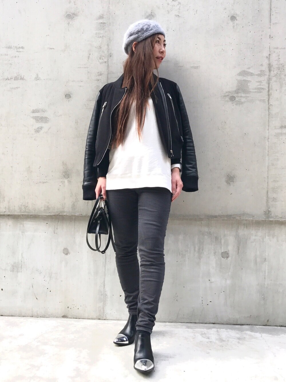 ブラック系のブルゾン、ホワイト系のニット/セーター、シルバー系のブーツを着用したレディースの冬コーディネートの1枚目の写真