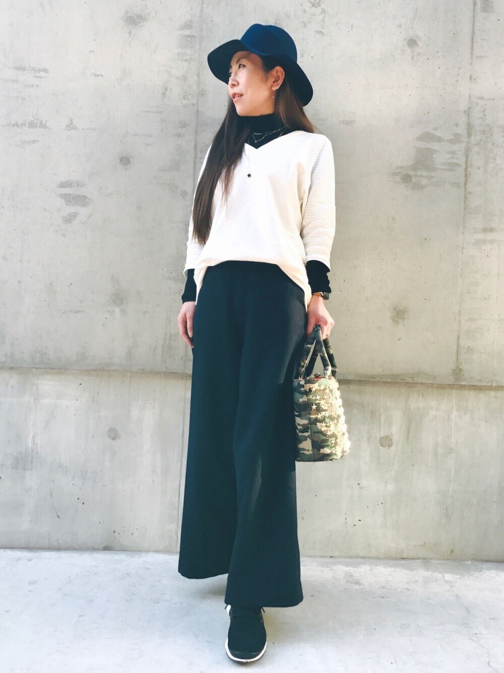 ブルー系のその他パンツ、ブラック系のスニーカー、ホワイト系のニット/セーターを着用したレディースの冬コーディネートの1枚目の写真