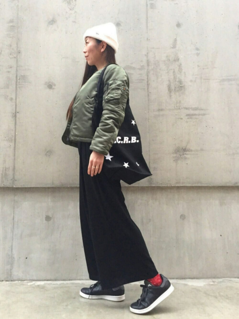 ブラック系のトートバッグ、ブラック系のスニーカー、ホワイト系のニット/セーターを着用したレディースの秋コーディネートの1枚目の写真