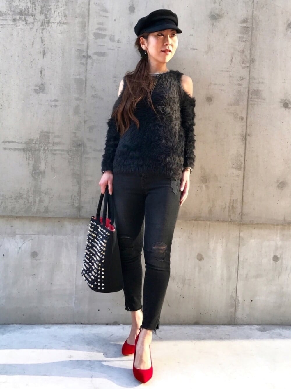 ブラック系のニット/セーター、ブラック系のデニムパンツ、レッド系のパンプスを着用したレディースの冬コーディネートの1枚目の写真