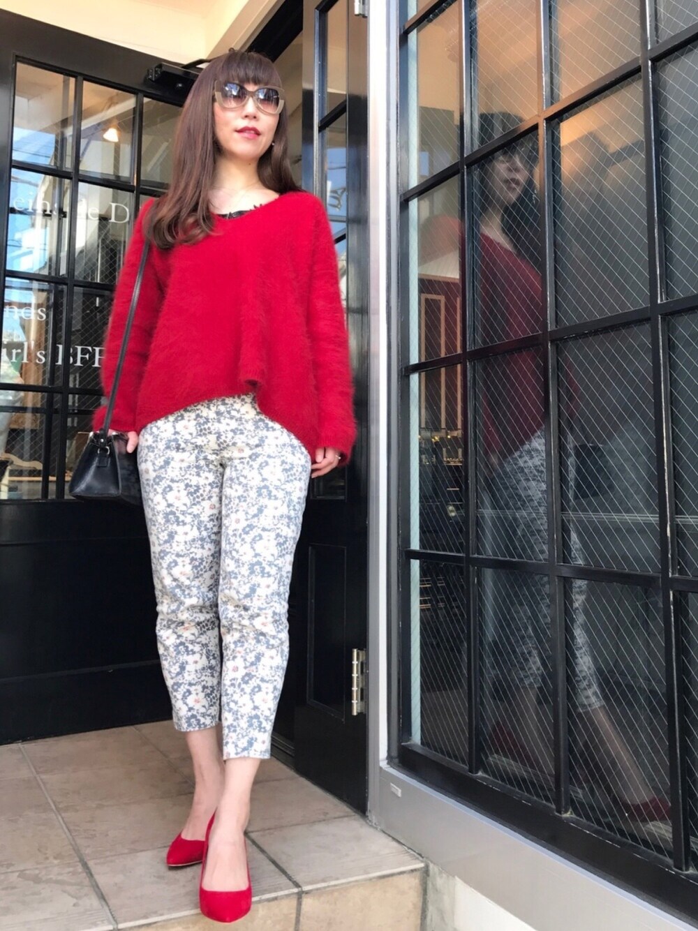 レッド系のニット/セーター、グレー系のその他パンツ、レッド系のパンプスを着用したレディースの冬コーディネートの1枚目の写真