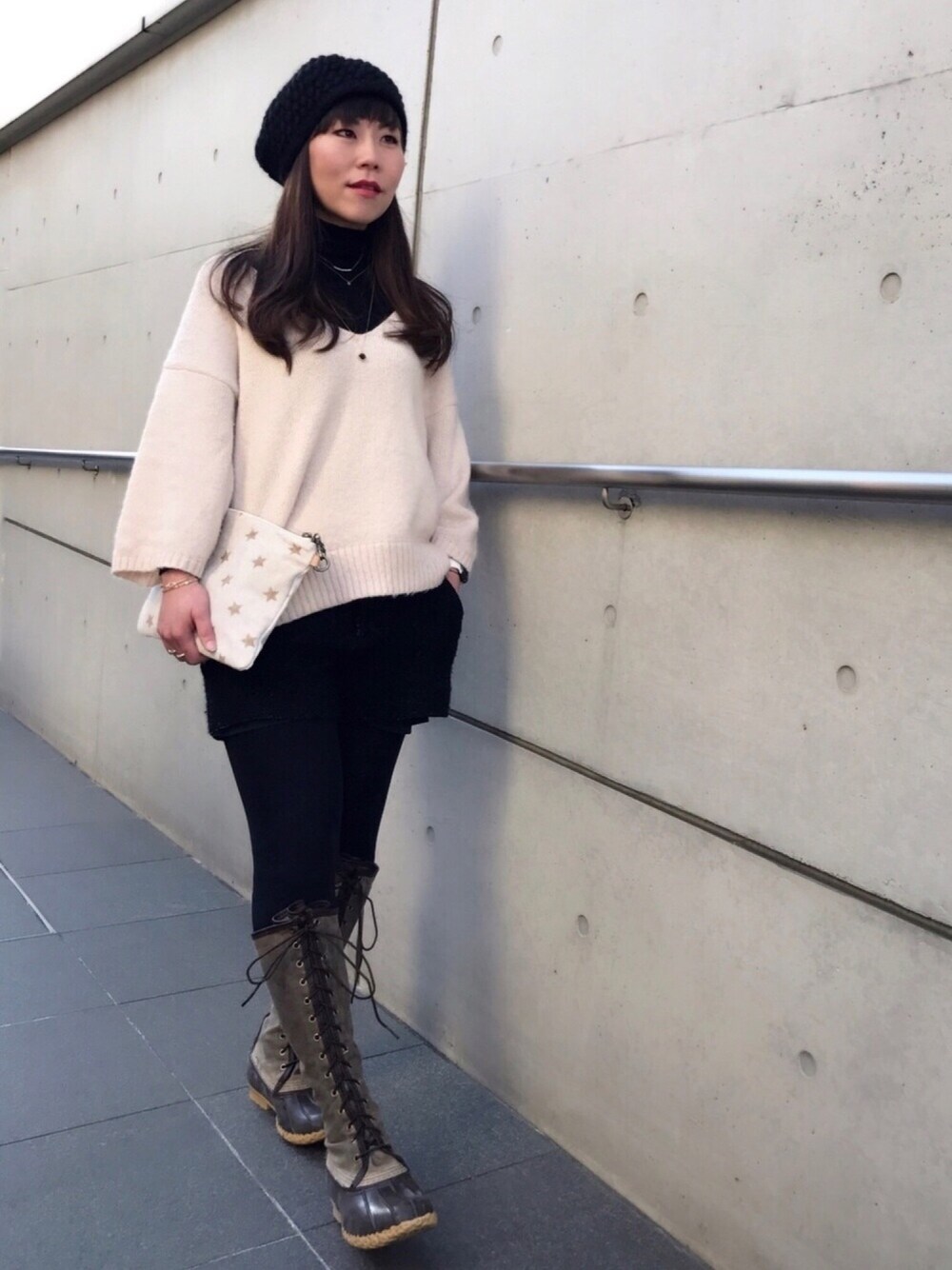 ブラウン系のブーツ、ホワイト系のニット/セーター、ブラック系のその他パンツを着用したレディースの冬コーディネートの1枚目の写真
