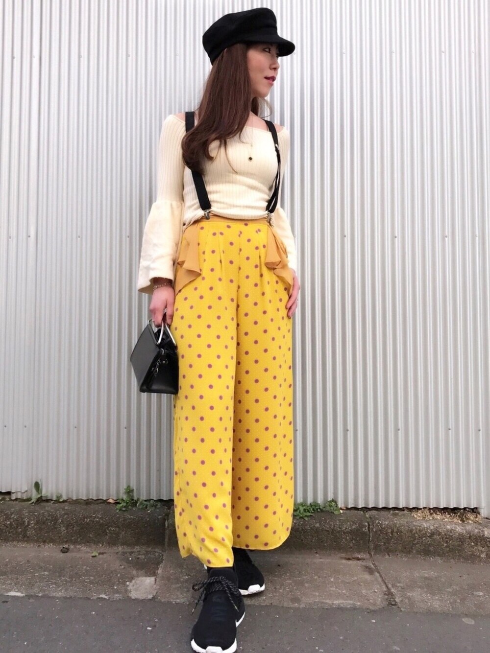 ベージュ系のニット/セーター、オレンジ系のその他パンツ、ブラック系のスニーカーを着用したレディースの春コーディネートの1枚目の写真