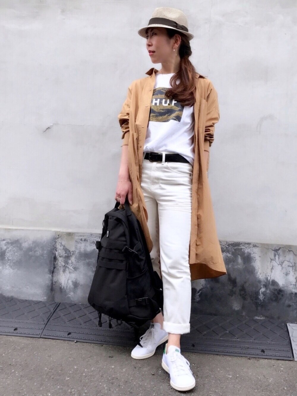 ベージュ系のシャツワンピース、ホワイト系のTシャツ/カットソー、ブラック系のバックパック/リュックを着用したレディースの春コーディネートの1枚目の写真