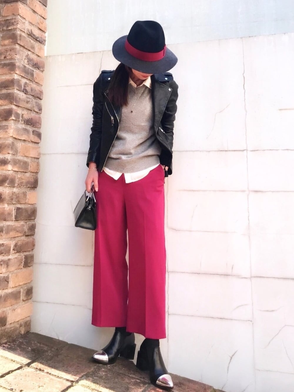 ブラック系のライダースジャケット、グレー系のニット/セーター、ピンク系のその他パンツを着用したレディースの秋コーディネートの1枚目の写真