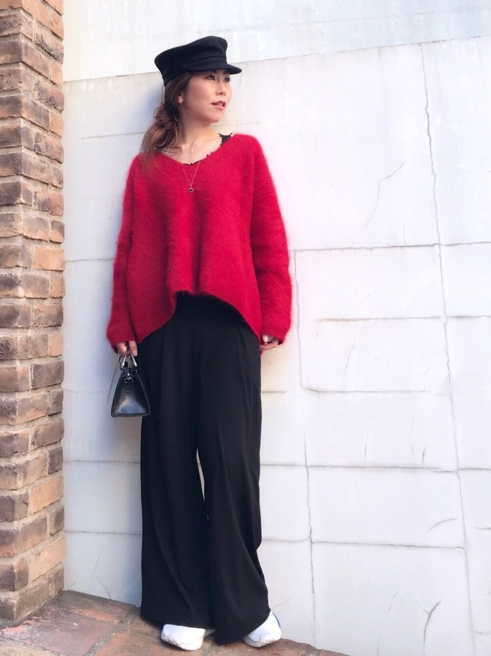 レッド系のニット/セーター、ホワイト系のスニーカー、ブラック系のその他パンツを着用したレディースの秋コーディネートの1枚目の写真