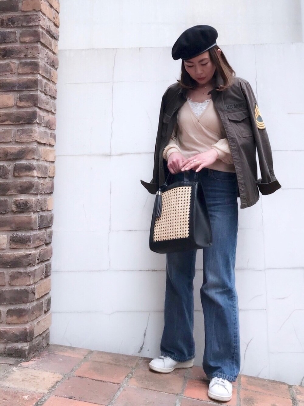 グリーン系のシャツ/ブラウス、ブルー系のデニムパンツ、ベージュ系のニット/セーターを着用したレディースの春コーディネートの1枚目の写真