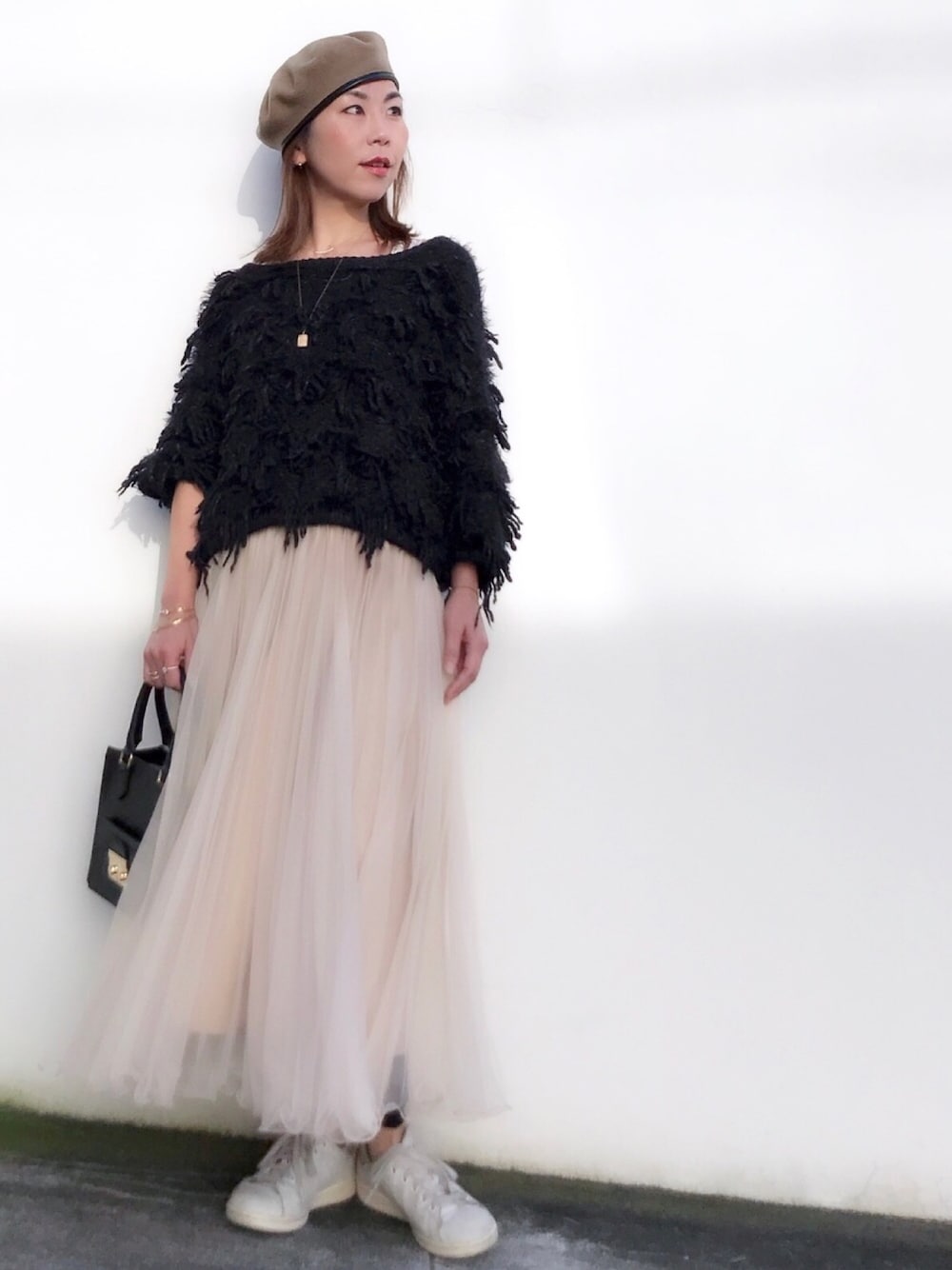 ベージュ系のスカート、ブラック系のニット/セーター、ブラック系のショルダーバッグを着用したレディースの秋コーディネートの1枚目の写真