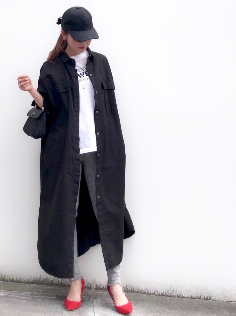 ブラック系のシャツワンピース、ホワイト系のTシャツ/カットソー、グレー系のデニムパンツを着用したレディースの春コーディネートの1枚目の写真