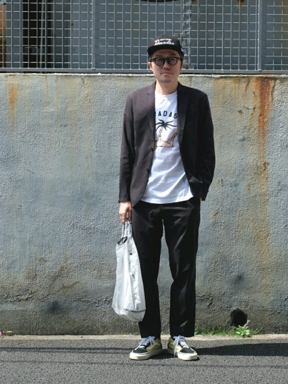 グレー系のセットアップ、ホワイト系のエコバッグ/サブバッグ、イエロー系のスニーカーを着用したメンズの春コーディネートの1枚目の写真