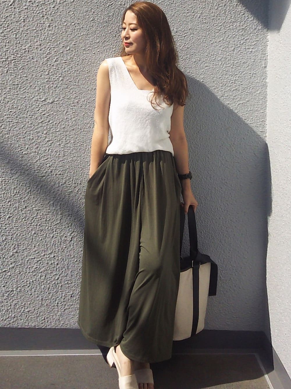 ホワイト系のニット/セーター、ホワイト系のハンドバッグ、グリーン系のその他パンツを着用したレディースの夏コーディネートの1枚目の写真