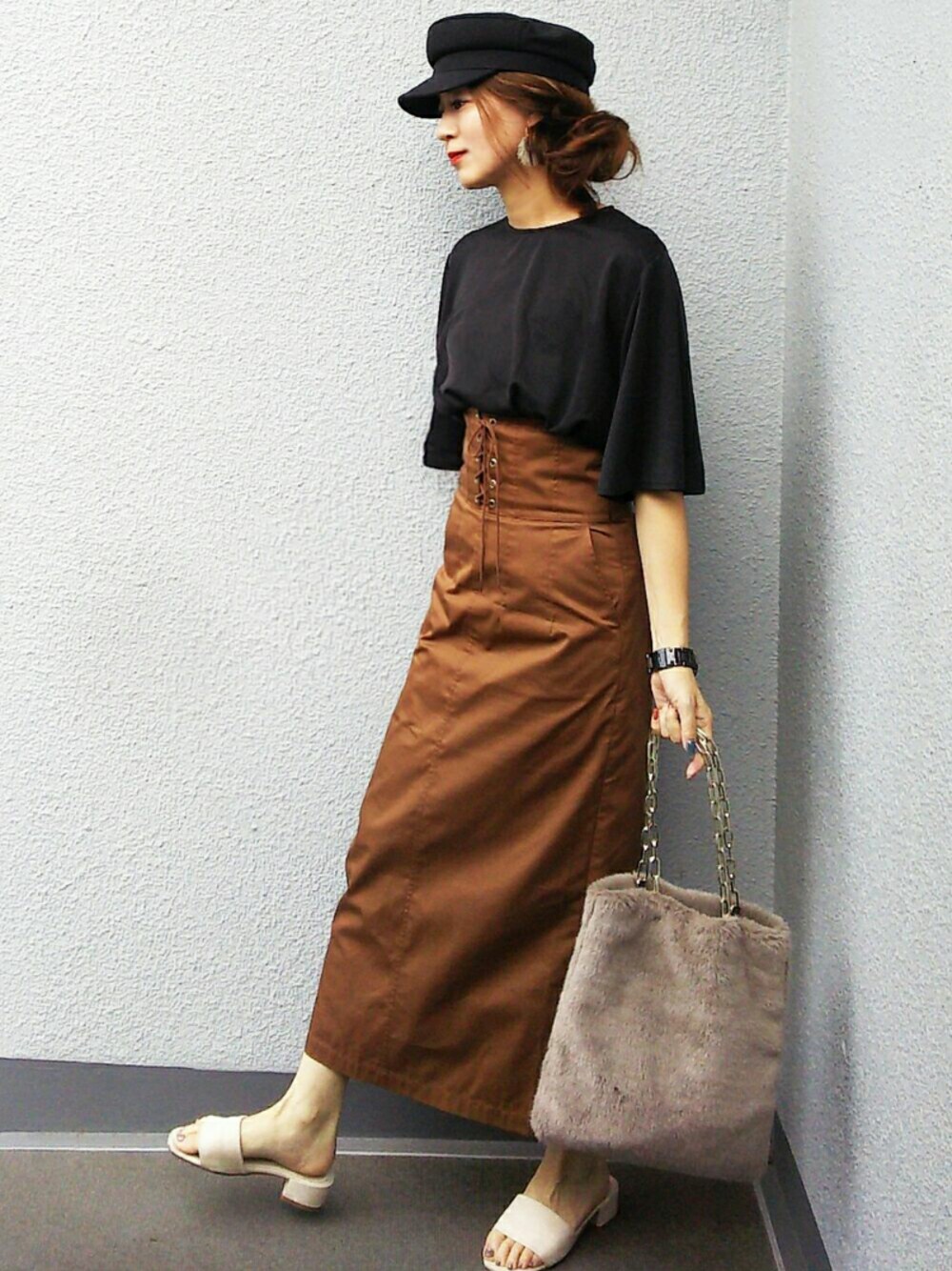 ブラック系のその他トップス、ブラウン系のスカート、グレー系のハンドバッグを着用したレディースの秋コーディネートの1枚目の写真