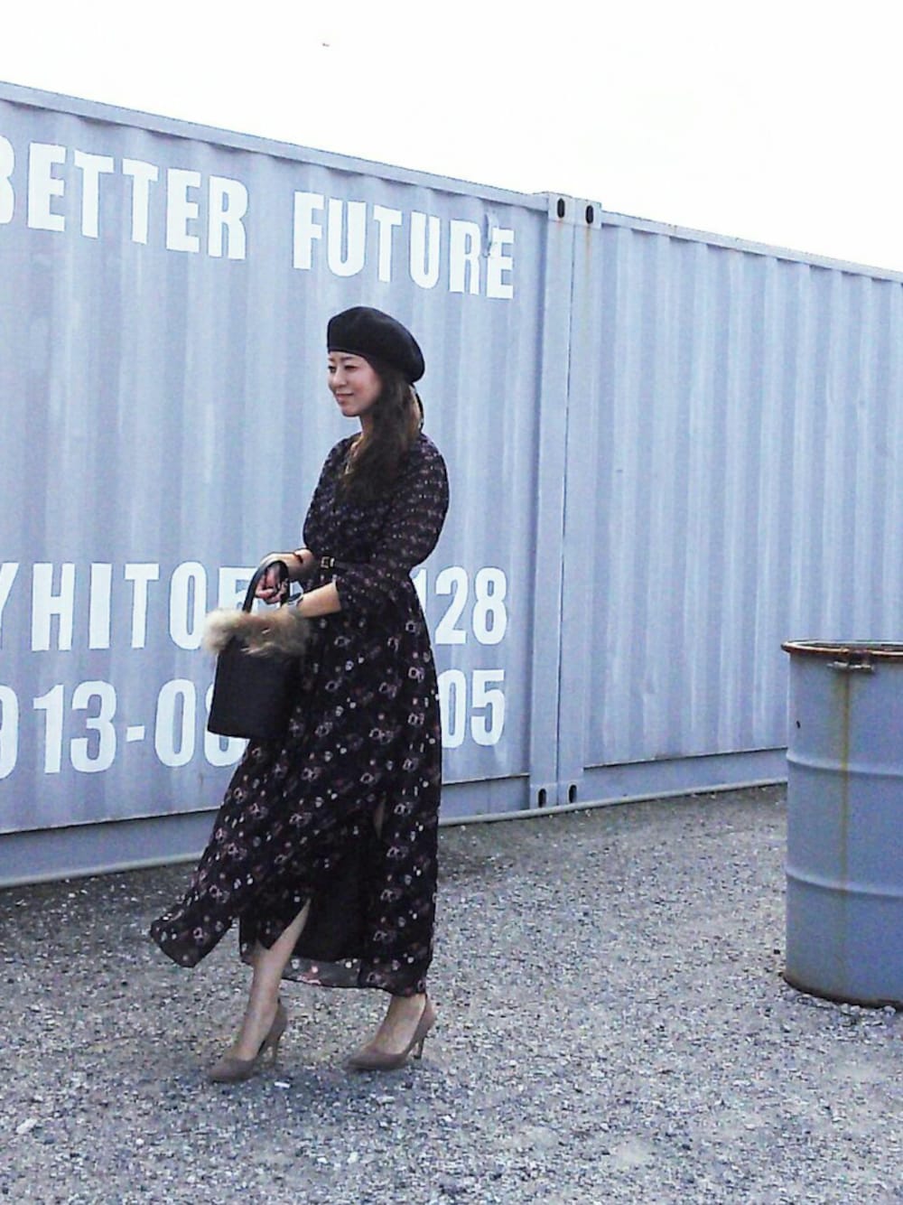 ベージュ系のパンプス、ブラック系のワンピース、ブラック系のショルダーバッグを着用したレディースの秋コーディネートの1枚目の写真