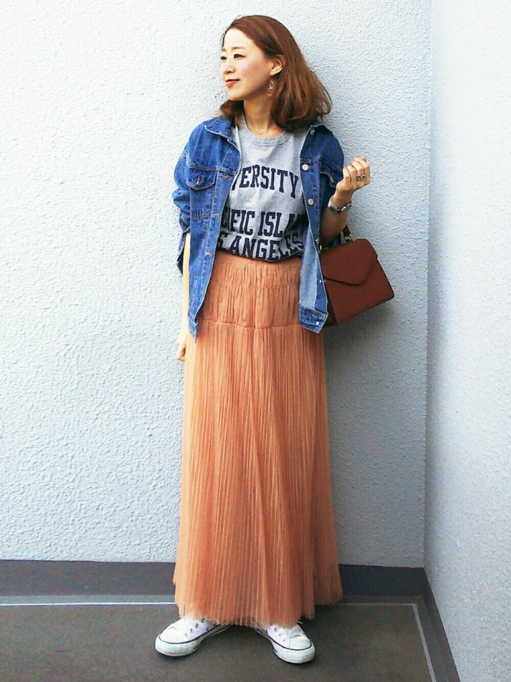 グレー系のTシャツ/カットソー、ホワイト系のスニーカー、オレンジ系のスカートを着用したレディースの春コーディネートの1枚目の写真
