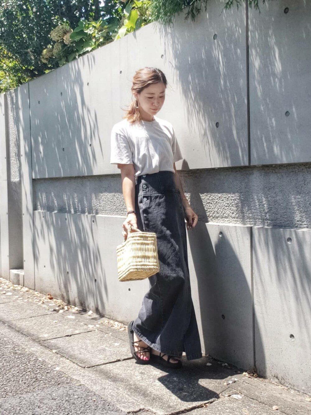 ブラック系のスカート、グレー系のTシャツ/カットソー、ブラック系のサンダルを着用したレディースの夏コーディネートの1枚目の写真