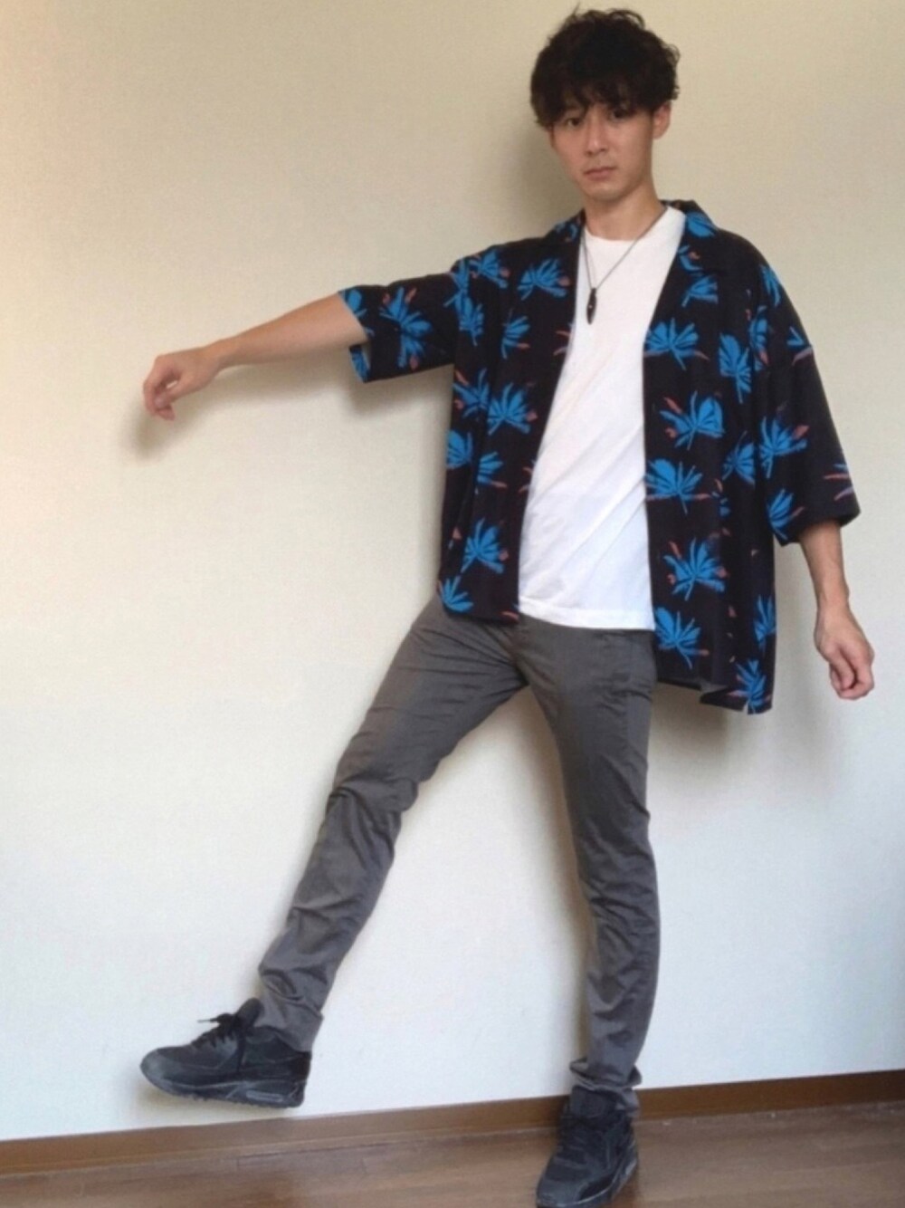 ホワイト系のスニーカー、ブラック系のシャツ/ブラウス、グレー系のスラックスを着用したメンズの夏コーディネートの1枚目の写真