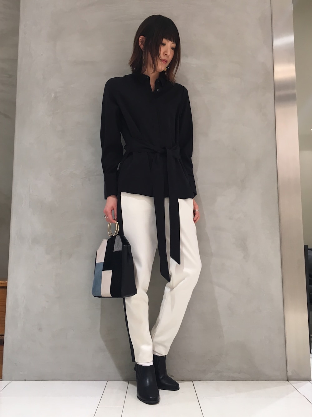ブラック系のシャツ/ブラウス、ホワイト系のその他パンツ、ブラック系のハンドバッグを着用したレディースの冬コーディネートの1枚目の写真