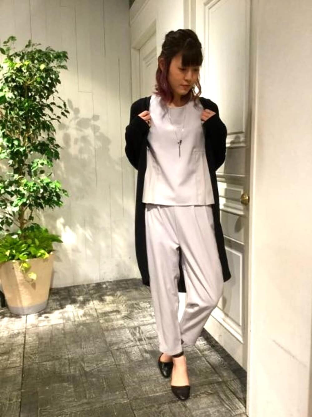グレー系のワンピース、ブラック系のカーディガン/ボレロ、ブラック系のパンプスを着用したレディースの春コーディネートの1枚目の写真