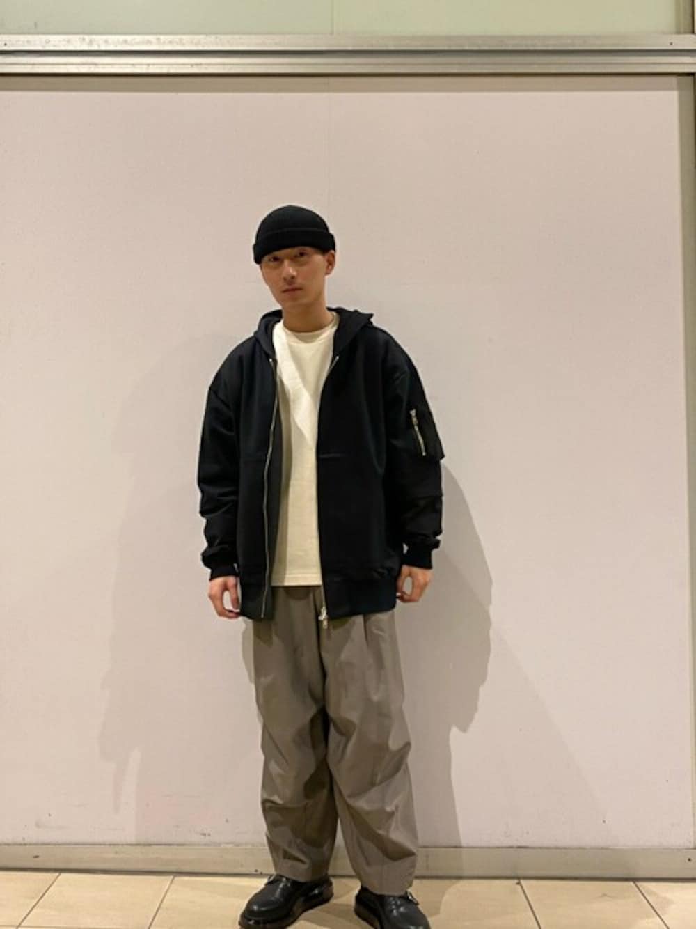 グレー系のカーゴパンツ、ブラック系のブルゾン、ホワイト系のスウェットを着用したメンズの春コーディネートの1枚目の写真