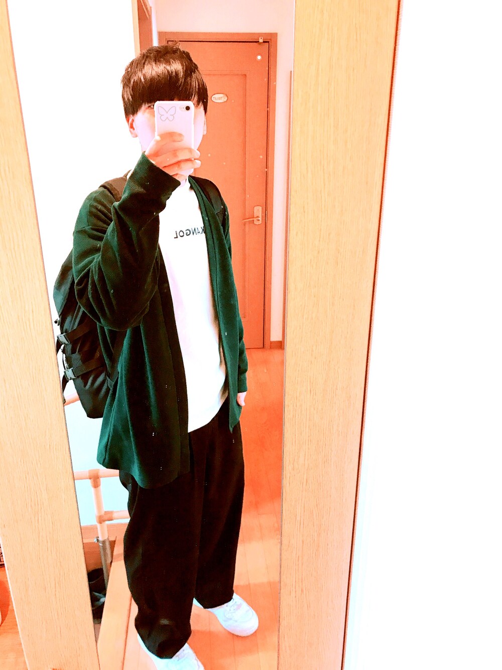 ホワイト系のスニーカー、ブラック系のスラックス、ホワイト系のTシャツ/カットソーを着用したメンズの春コーディネートの1枚目の写真