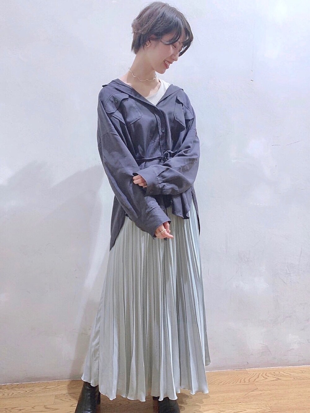 グレー系のシャツ/ブラウス、グリーン系のスカート、ブラック系のブーツを着用したレディースの秋コーディネートの1枚目の写真