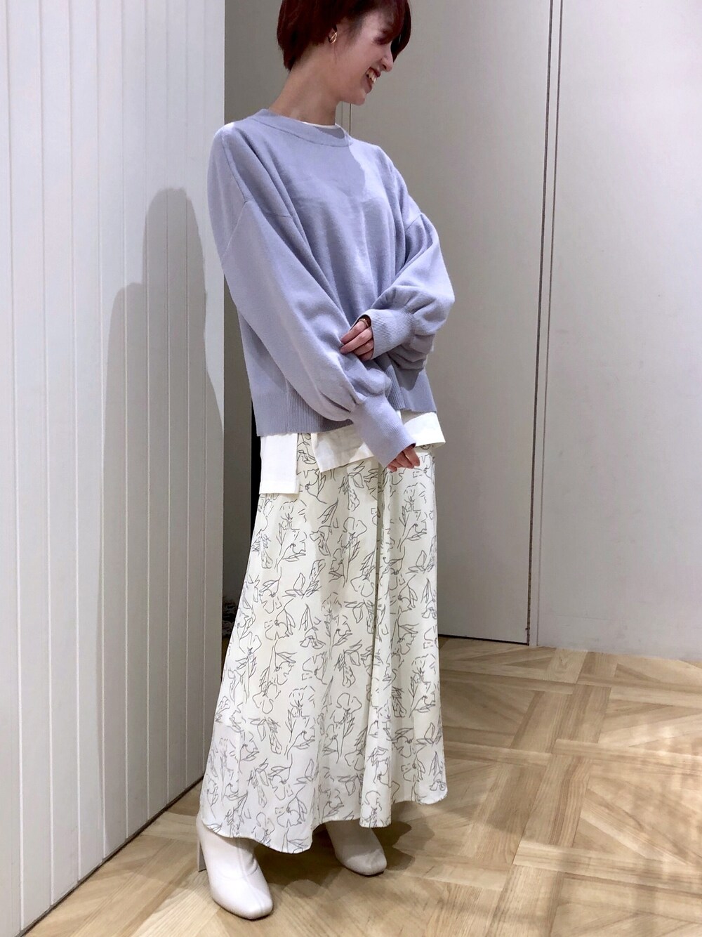 ブルー系のニット/セーター、ホワイト系のTシャツ/カットソー、ホワイト系のスカートを着用したレディースの冬コーディネートの1枚目の写真