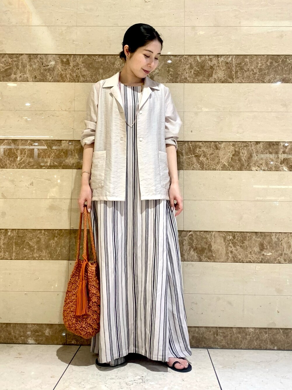 ホワイト系のシャツ/ブラウス、ブラック系のワンピース、オレンジ系のショルダーバッグを着用したレディースの春コーディネートの1枚目の写真