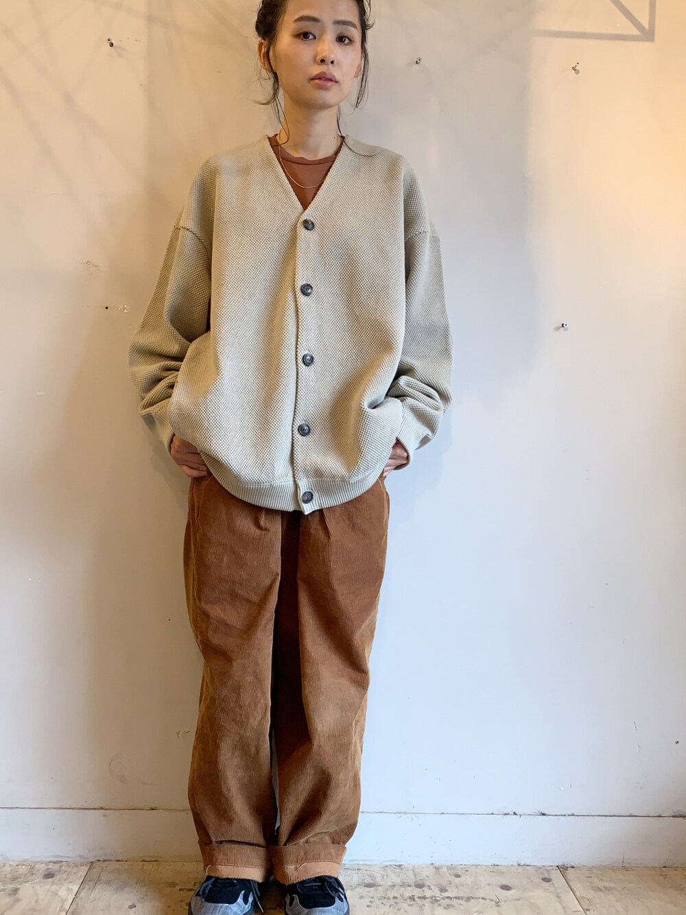 ベージュ系のカーディガン/ボレロ、ブラウン系のその他パンツ、ブラック系のスニーカーを着用したレディースの秋コーディネートの1枚目の写真