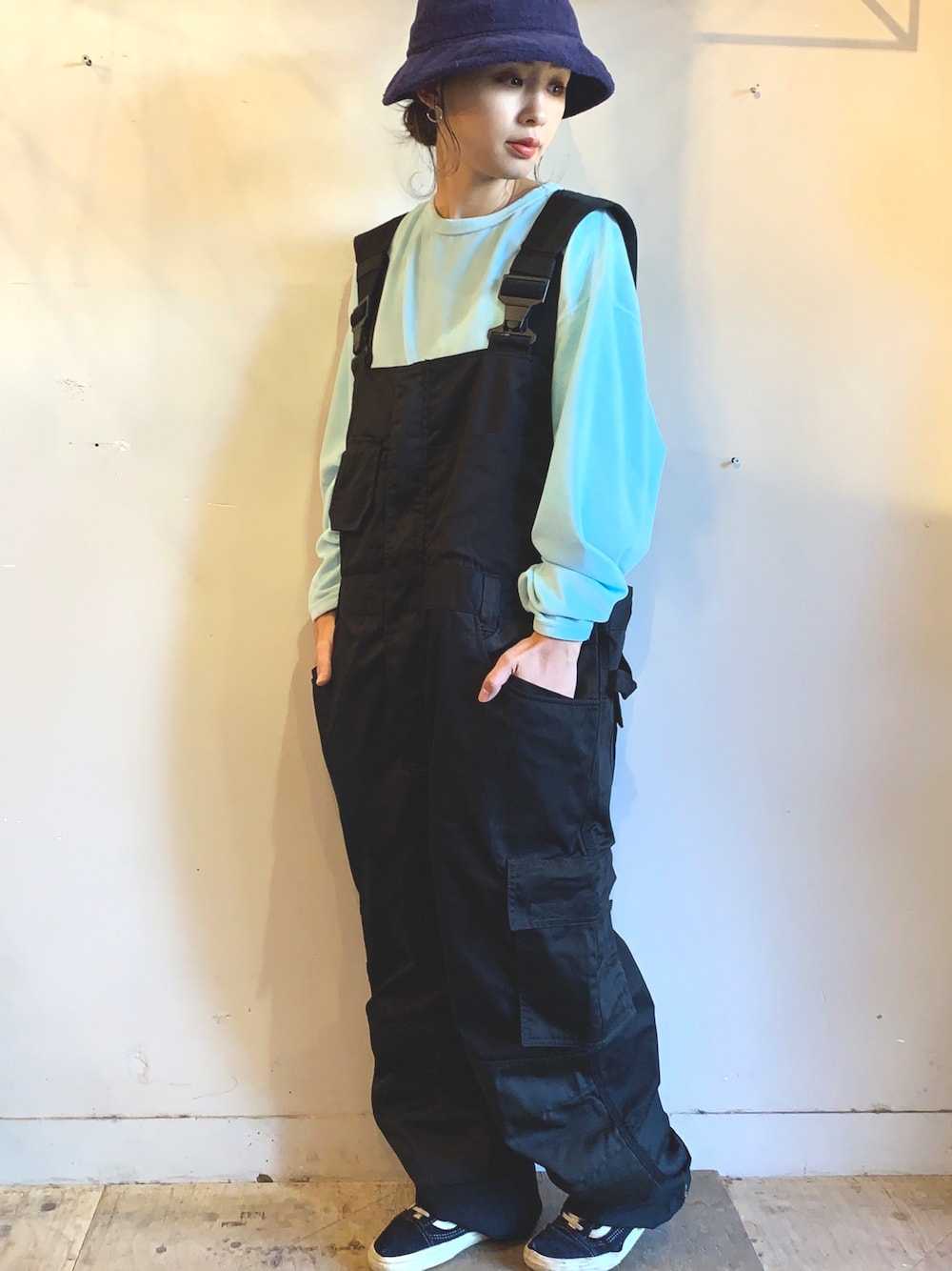 ブラック系のサロペット/オーバーオール、ブルー系のスニーカー、ブルー系のTシャツ/カットソーを着用したレディースの秋コーディネートの1枚目の写真