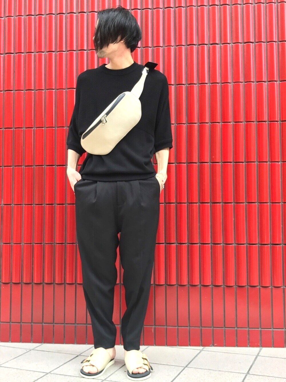 ブラック系のニット/セーター、ブラック系のタンクトップ、ベージュ系のサンダルを着用したメンズの夏コーディネートの1枚目の写真