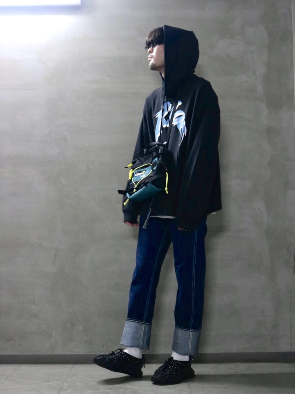ブラック系のパーカー、ブルー系のボディバッグ/ウエストポーチ、ホワイト系のTシャツ/カットソーを着用したメンズの春コーディネートの1枚目の写真