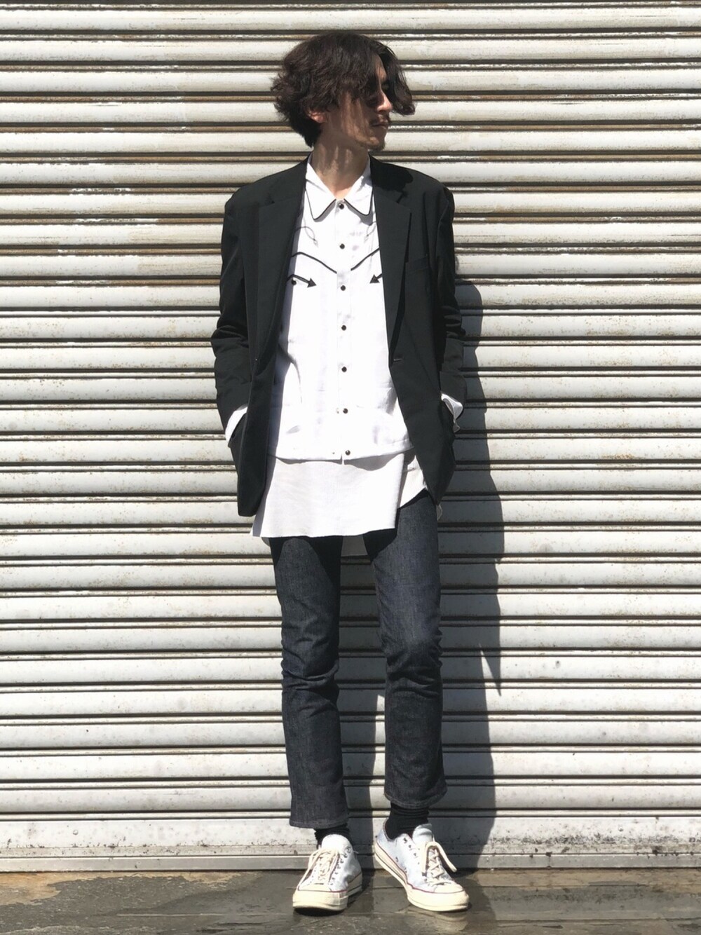 ブラック系のテーラードジャケット、ホワイト系のシャツ/ブラウス、ブルー系のデニムパンツを着用したメンズの春コーディネートの1枚目の写真