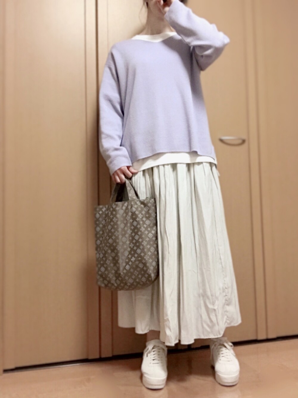 パープル系のニット/セーター、ホワイト系のTシャツ/カットソー、グレー系のスカートを着用したレディースの春コーディネートの1枚目の写真